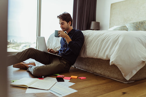 Young businessman working from home drinking coffee