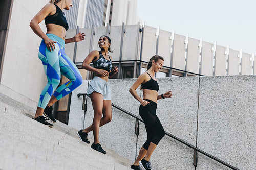 Smiling women in training clothes walking down the stairs