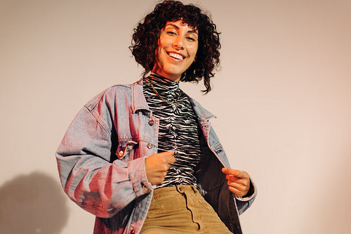 Happy young woman wearing a denim jacket and jewellery