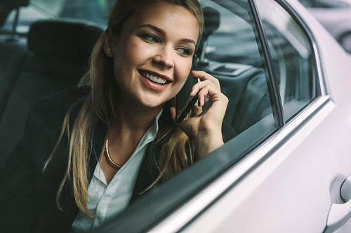 Business executive travelling by a taxi and making phone call