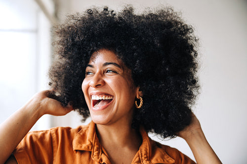 Black businesswoman with Afro hair smiling happily in an office