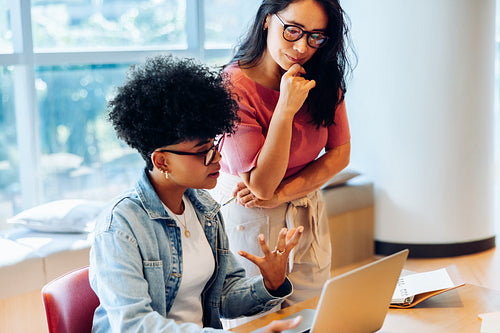 Businesswomen reviewing project details together