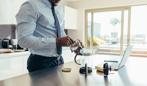 Businessman preparing coffee at home