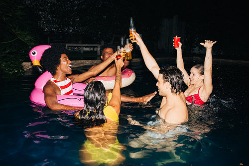 Friends raise drinks at pool party