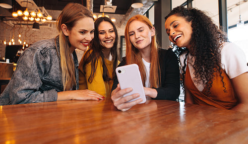 Friends looking at photos on mobile phone