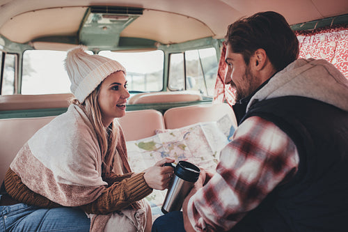 Couple on a road trip sitting inside their van