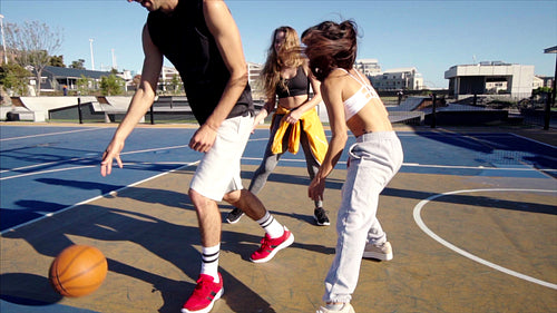 Group of athletic young people playing basketball together