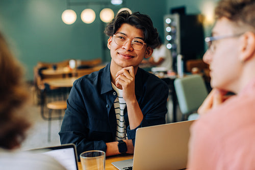 Young professionals collaborating in a modern cafe meeting area