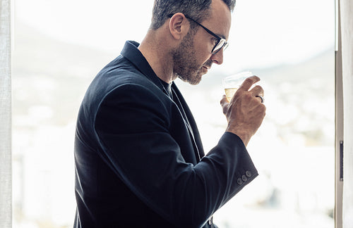 Mature businessman having a drink in hotel room