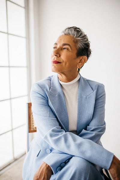 Senior business woman sitting on a chair and looking outside the window in an office