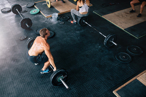 Muscular man exercising with heavy weights in gym