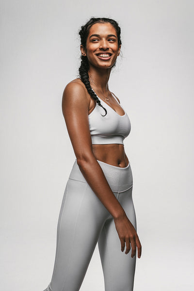 Smiling female athlete walking against white background