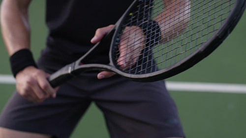 Tennis player holding a tennis racket on hard court