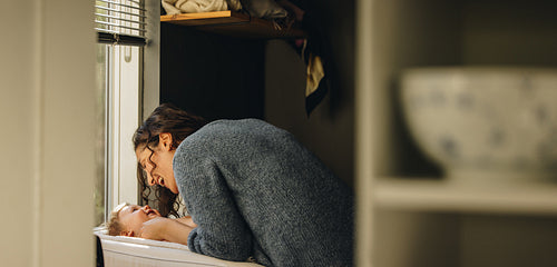 Loving mother changing diaper of her baby