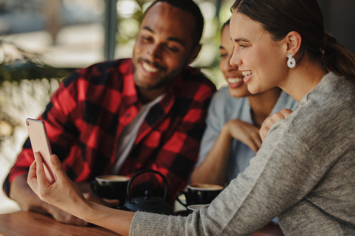Friends watching photos on mobile phone