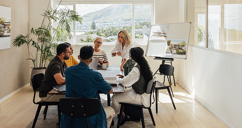 Team discussion among architects in a modern office with large windows