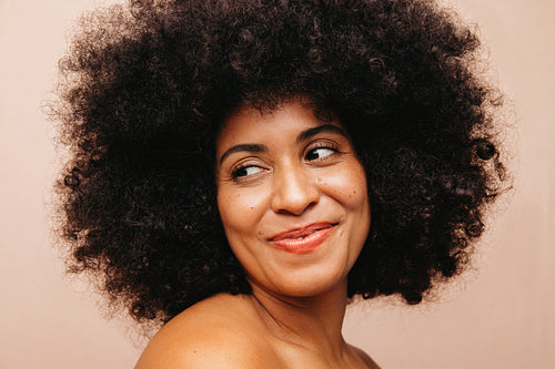 Self-confident woman with Afro hair smiling in a studio