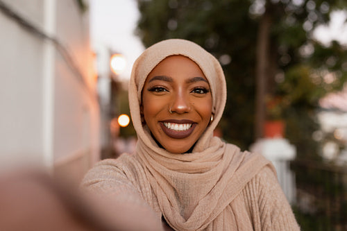 Cheerful muslim woman taking a selfie outdoors