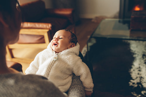 Mother sitting on sofa with her baby boy