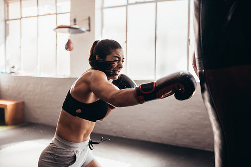 Female boxer training inside a boxing ring