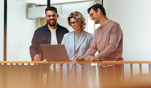 Happy business people video calling their associates on a laptop