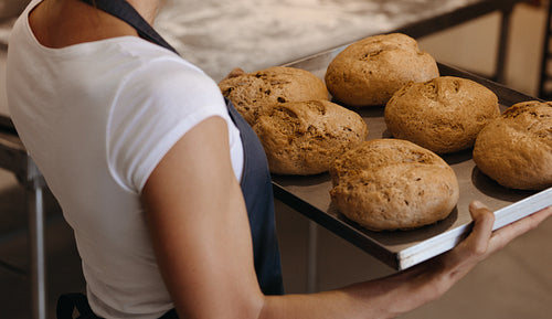Woman with a tray freshly baked bread