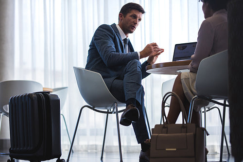 Business people waiting for flight at airport cafe