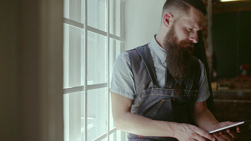 Happy young barber smiling at his barbershop
