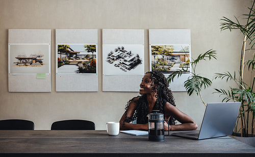 Young professional architect working at a creative design office with blueprints displayed