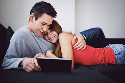 Affectionate teenage couple using tablet PC - Indoors