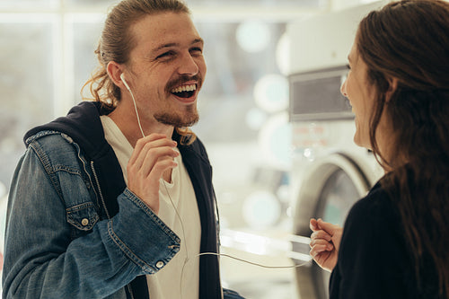 Smiling couple listening to music on earphones