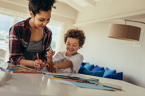 Woman helping her son in doing school homework