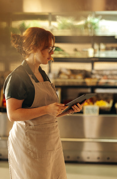 Young woman stocktaking in a modern grocery store