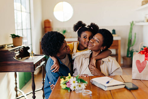Love and joy: Mom and kids embracing with birthday bouquets