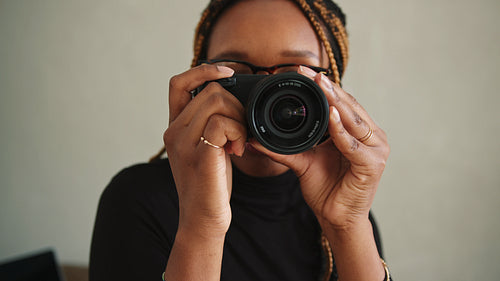 Happy female photographer taking photos in her studio