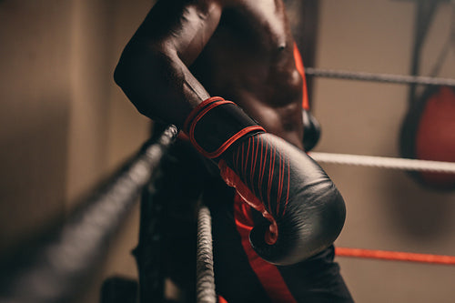 Boxer resting against the ropes of a boxing ring