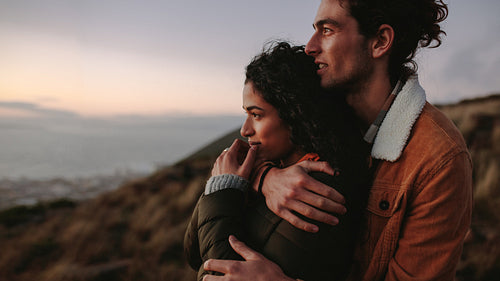 Loving couple together on mountain looking at a view