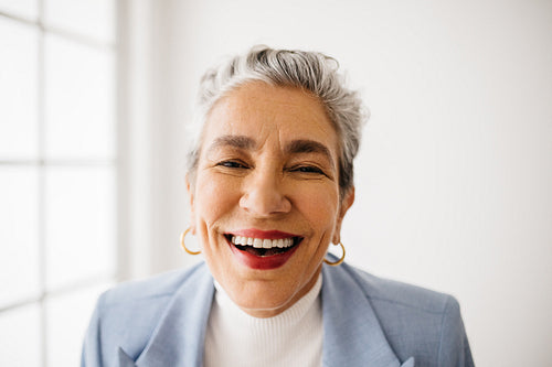 Celebrating a successful career: Mature business woman smiling in her office