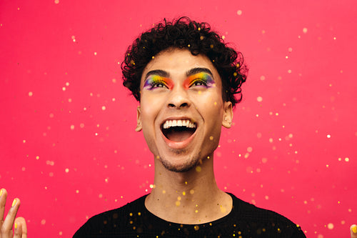 Excited gay man throwing glitter