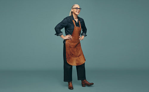 Happy female goldsmith smiling in a studio