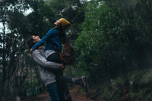 Yung couple enjoying in rain at forest