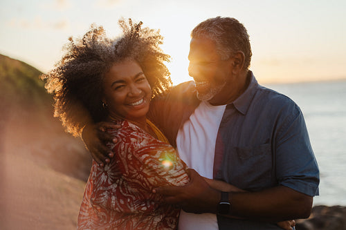 Senior couple embracing at sunset, radiating love and happiness