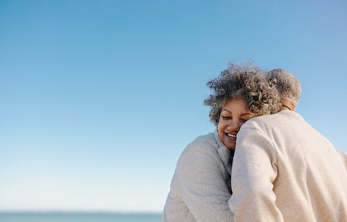 Affectionate senior woman smiling while leaning on her husband