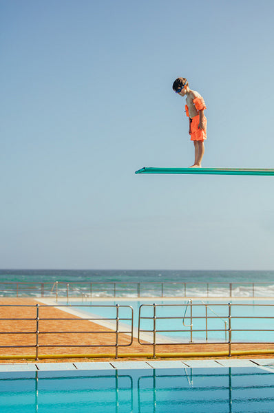 Boy learning to dive at swimming pool