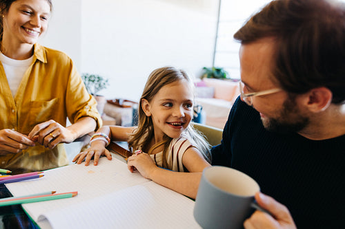 Family moment at the table with daughter drawing