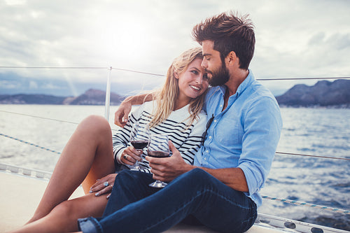 Romantic couple sailing on a boat with wine