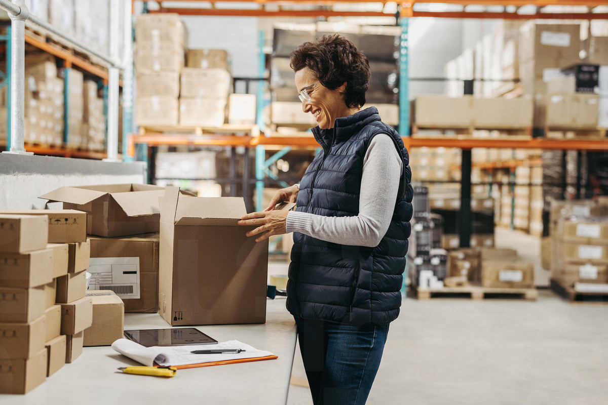 Happy warehouse manager packing a cardboard box – Jacob Lund ...