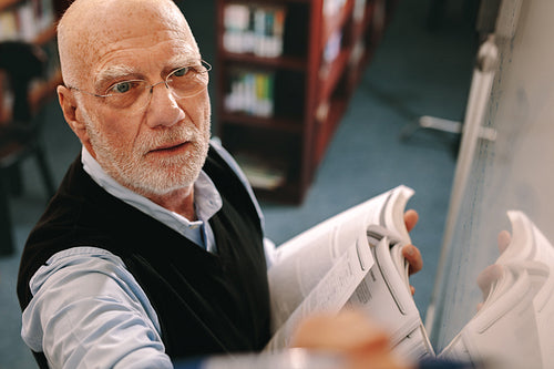 Close up of a professor writing on board in classroom
