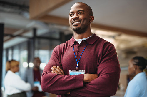 Businessman smiling with arms crossed at a networking event
