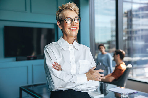 Experienced female professional standing in a business boardroom